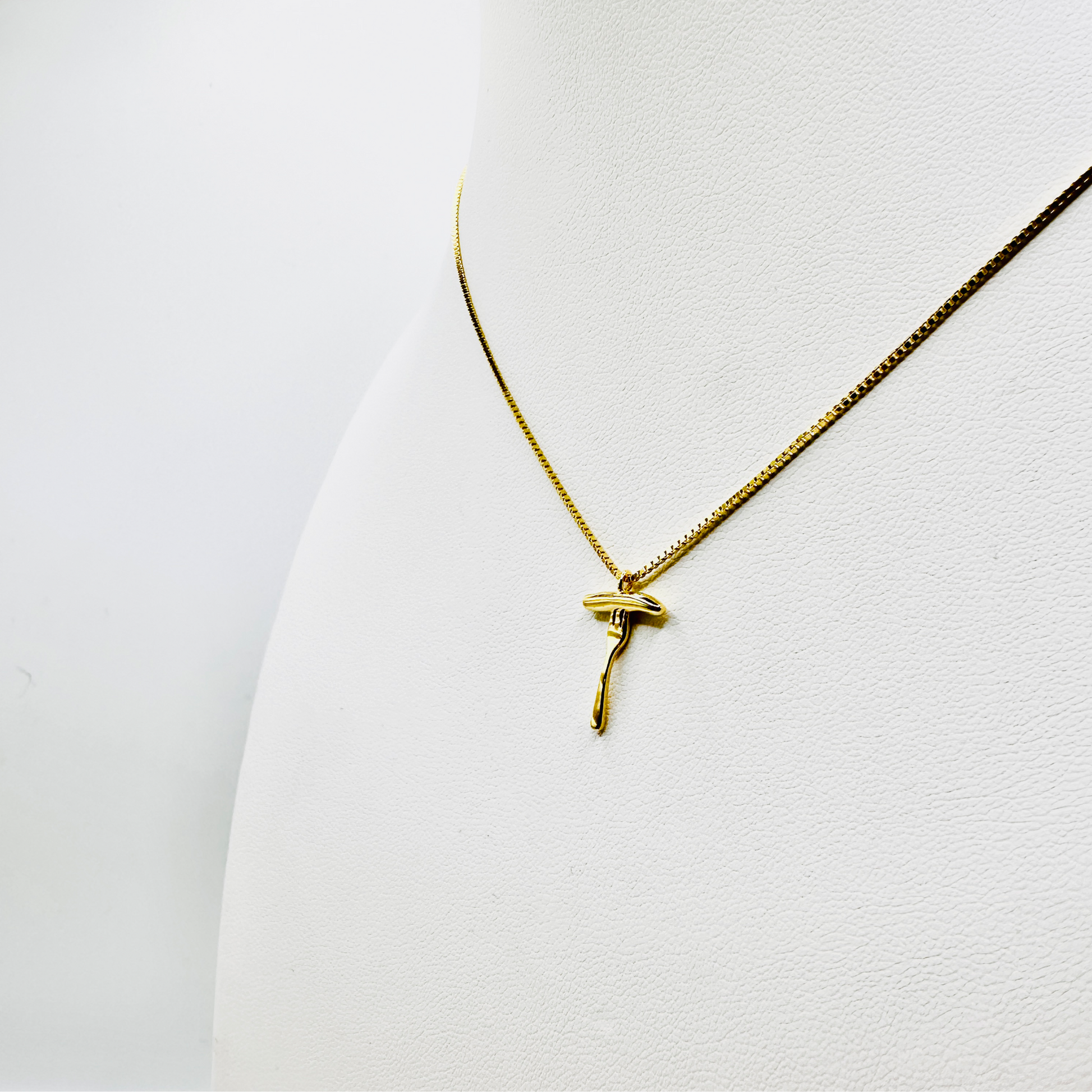 Eine elegante goldene Halskette mit einem Anhänger in Form einer Bratwurst auf einer Gabel wird auf einem weißen Schmuckdisplay präsentiert. Die feine Kette hat eine glänzende 3 Micron Vergoldung auf Sterling Silber (925) und verleiht dem Schmuckstück einen edlen Look. Der filigrane Anhänger zeigt eine realistisch gestaltete Bratwurst auf einer Gabel, die für Tradition und Genuss steht. Das Design verbindet humorvolle Symbolik mit hochwertiger Verarbeitung.
