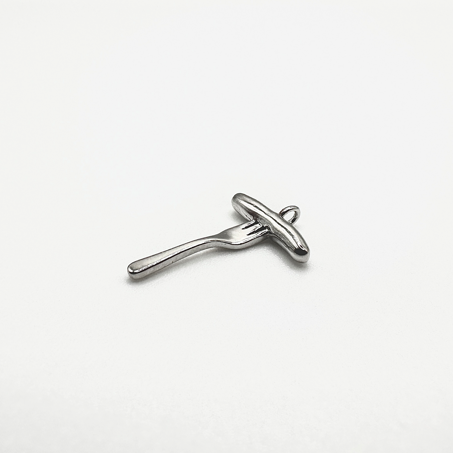 Nahaufnahme eines silbernen Anhängers in Form einer Bratwurst auf einer Gabel. Der Anhänger ist aus echtem Sterling Silber (925) gefertigt und hat eine glänzende Oberfläche. Das Design kombiniert traditionelle fränkische Kulinarik mit edlem Schmuckhandwerk. Durch die kleine Öse lässt sich der Charm flexibel an Ketten oder Armbändern befestigen – ein perfektes Accessoire für Feinschmecker und Nürnberg-Liebhaber.
